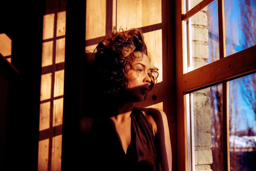 Icon Derma Clinic woman in evening dress standing near the window